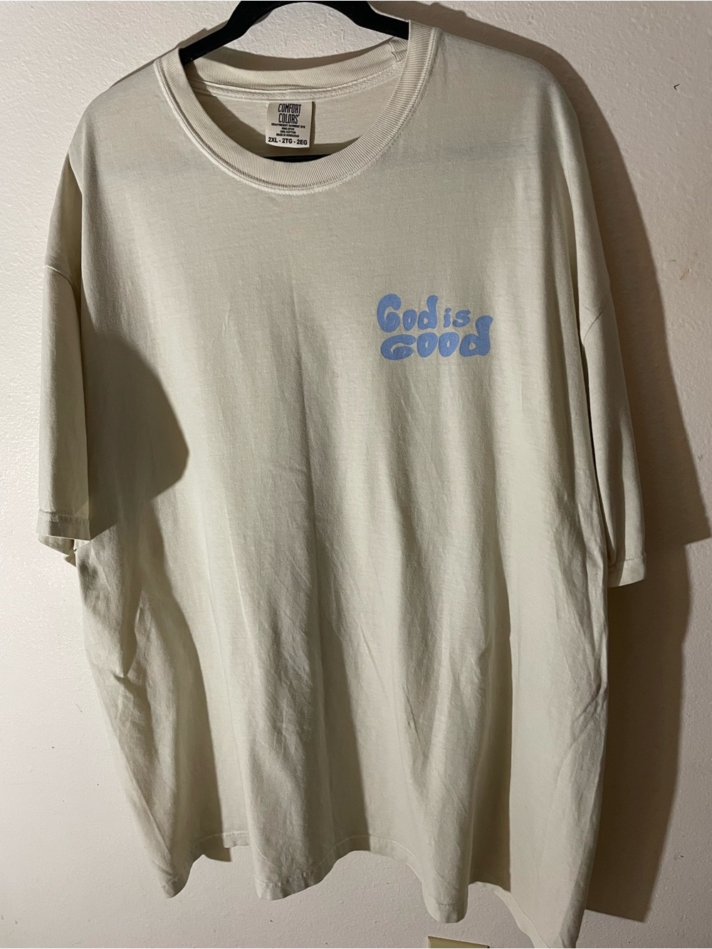 Comfort Colors Light Cream Tee with Blue "God is Good" Chest Graphic